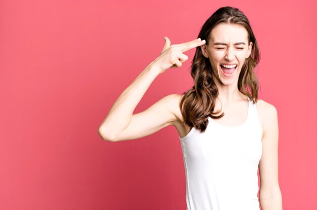 Looking unhappy and stressed suicide gesture making gun sign