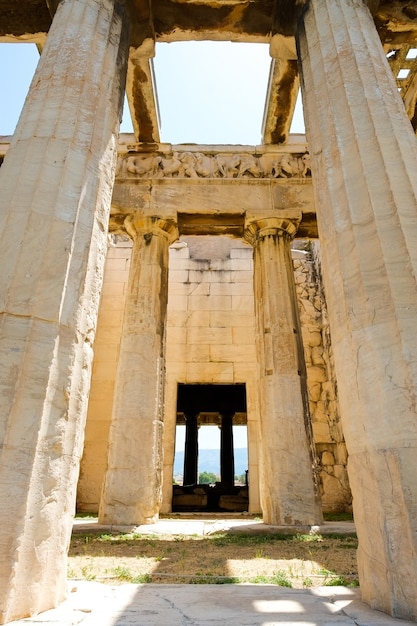 Looking up view of famous Greek temple pillars against clear blue sky in Greece