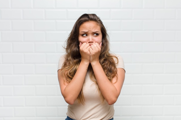 looking worried, anxious, stressed and afraid, biting fingernails and looking to lateral copy space