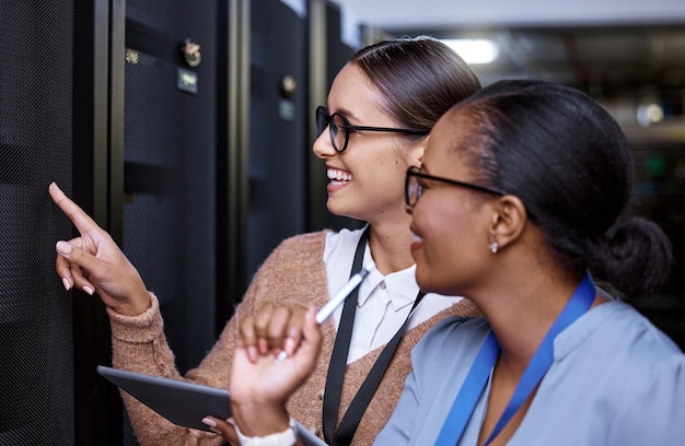 Looks like its all sorted Cropped shot of two attractive young female computer programmers working together in a server room