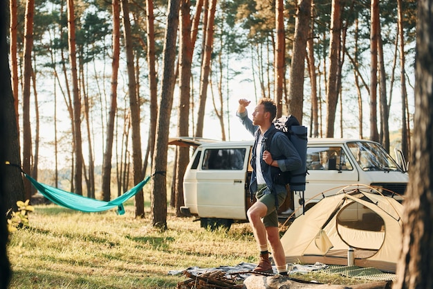 場所を見る男は夏の昼間に森の中を一人で旅行しています