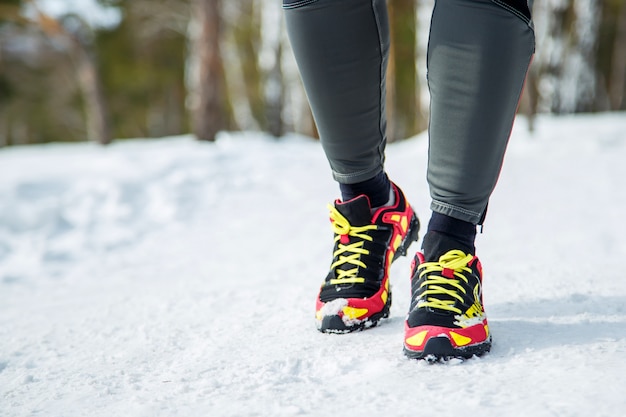 Loopschoenen - close-up van vrouwelijke sport fitness runner klaar om te joggen buiten in de winter