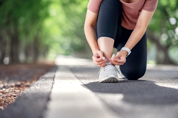 Foto loopschoenen runner vrouw koppelverkoop veters voor zomer lopen in bospark.