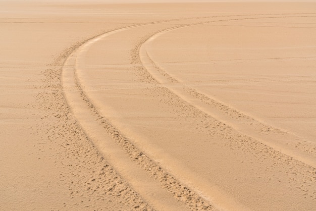 Loopvlaksporen van auto's in het zand