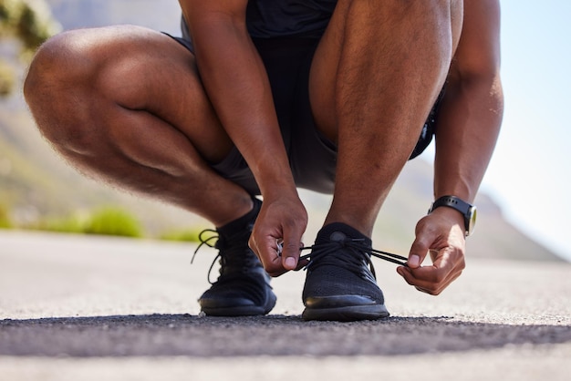 Lopende handen of persoon op de weg met schoenen voor fitnesstraining en marathontraining Close-up koppelverkoop veter of atleet runner klaar om te lopen, lopen of joggen met sneakers, trainers of schoeisel