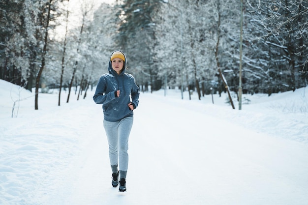Lopende vrouw tijdens haar joggingtraining tijdens de winter en besneeuwde dag