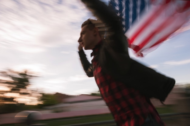 Foto lopende wazige man met amerikaanse vlag. trotse amerikaanse patriot viert nationale gebeurtenis. tiener op vakantie veel plezier op de onafhankelijkheidsdag