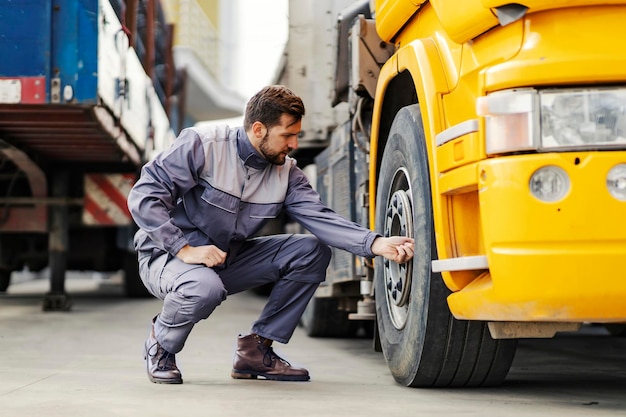 A lorry driver checking on tires before the trip