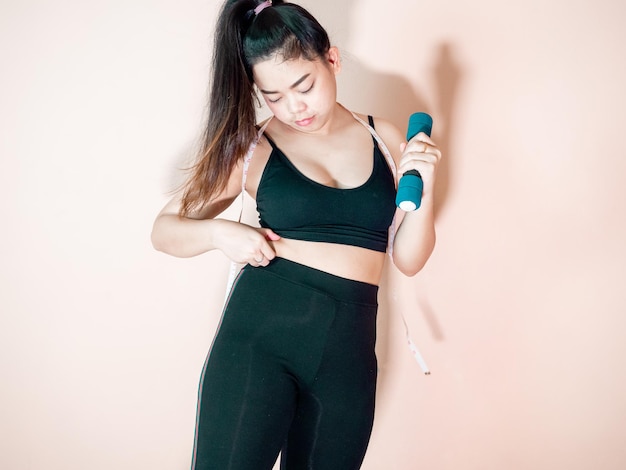 スポーツウェアを着た女性の腹脂肪を減らすコンセプトと健康な体のために運動する