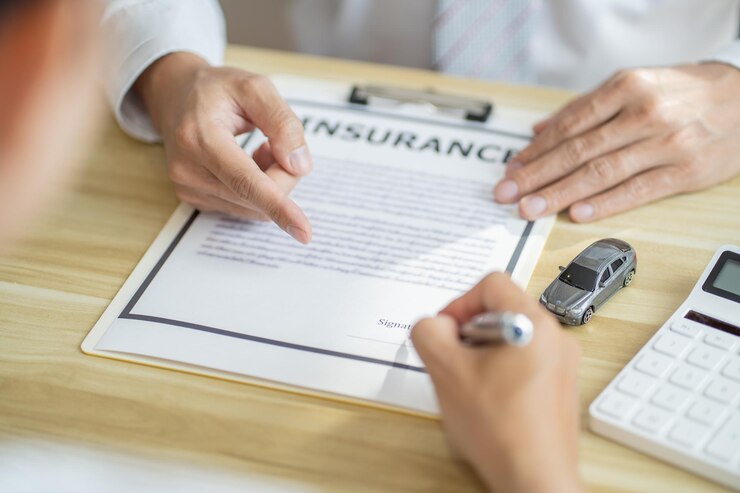 Photo loss adjuster insurance agent inspecting damaged car sales manager giving advice application form document considering mortgage loan offer for car insurance