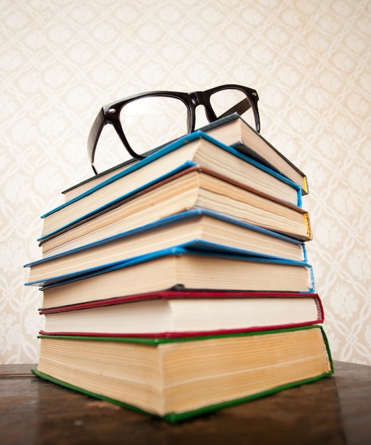 A lot of books for studying and black glasses