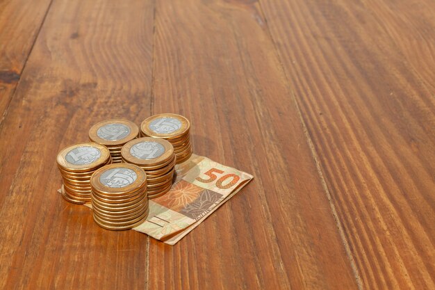 Photo lot of brazilian coins and bank notes on a wood table