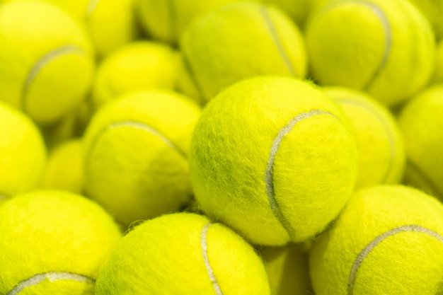 Lot of bright yellow tennis balls as a background closeup macro