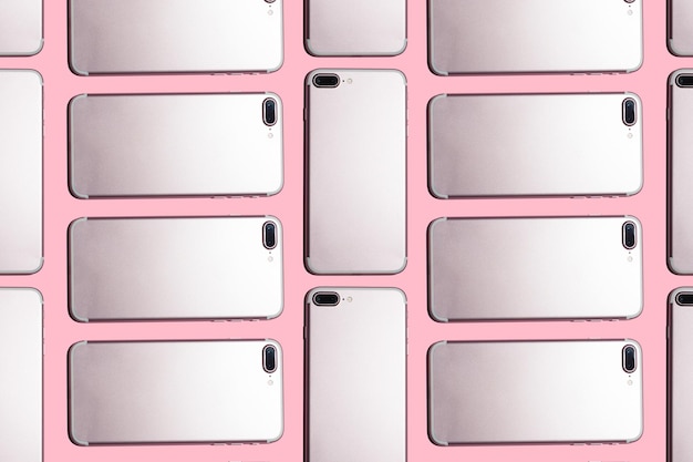 A lot of cell phones on a pink background pattern