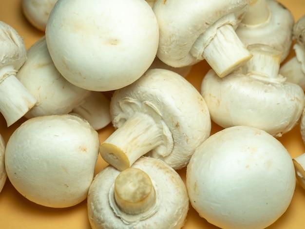 A lot of champignons on a beige background Kitchen table