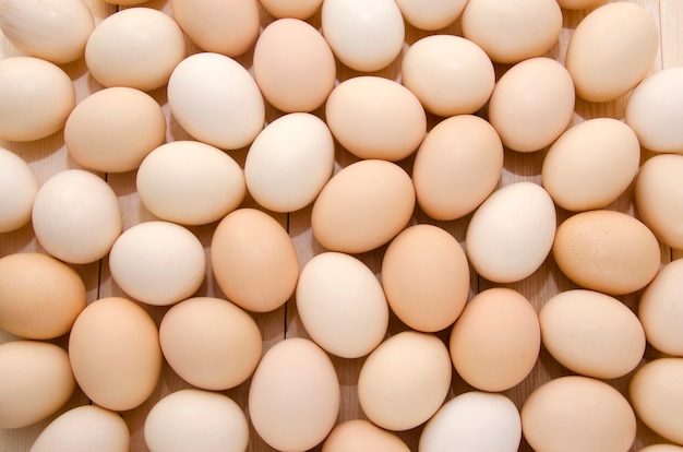 Photo a lot of chicken eggs on a wooden background