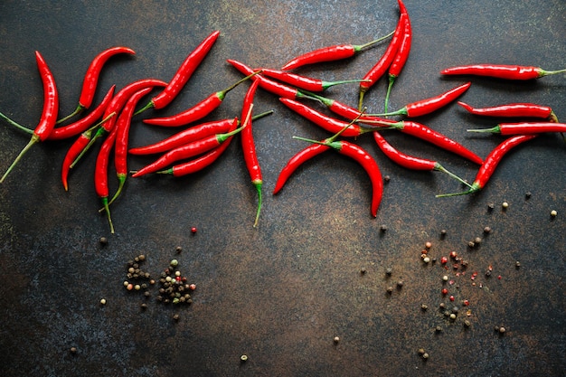 A lot of chili peppers on a kitchen table Top view