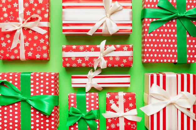 A lot of Christmas gift boxes in colored paper decorated on table Top view close up Many present New Year gift