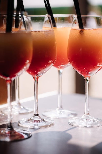 Lot of coctails on the table Glasses with orange alkohol drink