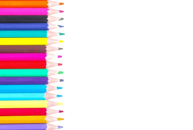 A lot of colored pencils lying in one line on a white background isolated