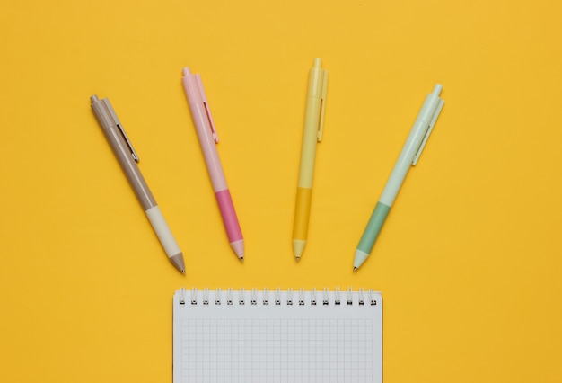 A lot of colored pens with notebook closeup