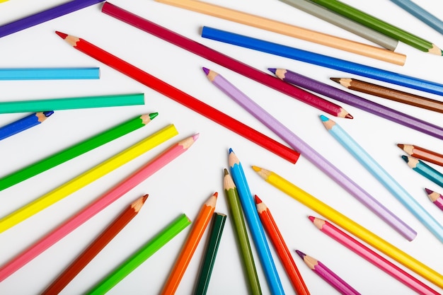 Много разноцветных карандашей на белом фоне Концепция школы рисования для детей или хобби вид сверху