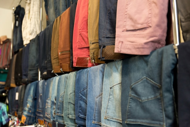 A lot of different blue jeans in the shop. Denim clothes store