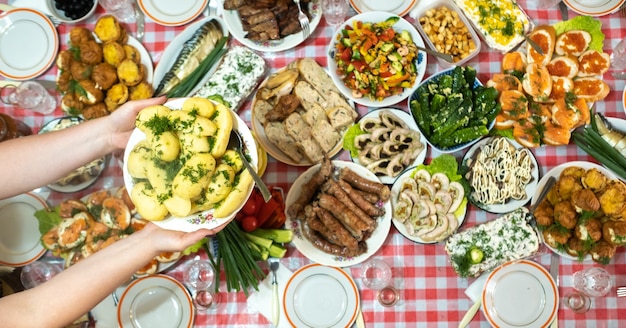 宴会テーブルにはさまざまな食べ物があり、茹でたジャガイモとディルを添えて