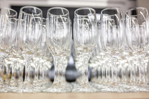 Foto molti bicchieri vuoti sul tavolo del ricevimento primo piano sulla fila di bicchieri prepararsi per il servizio per la cena