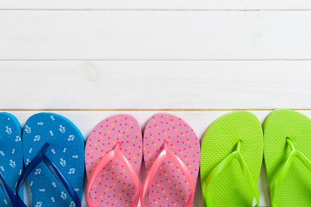 Photo a lot of flip flop colored sandals, summer vacation on wooden background, copy space top view