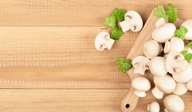 A lot of fresh champignons on a wooden table