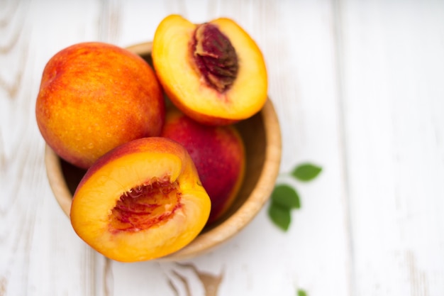 A lot of fresh peaches on a white table