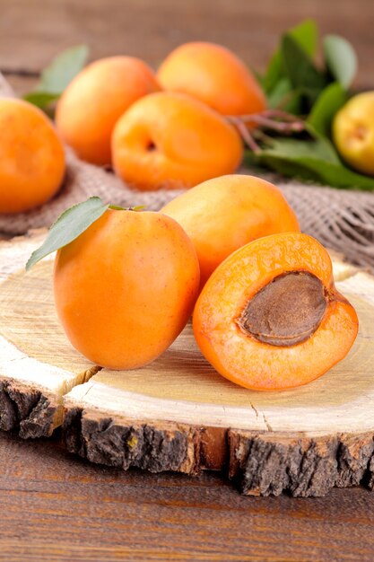 A lot of fresh, ripe apricot in a bag on a brown wooden table