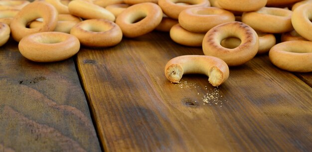 A lot of fresh yellow bagels lie on the surface of the old dark 