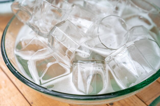 A lot of a glass of water glass in the glass sink ready for washing and clean.