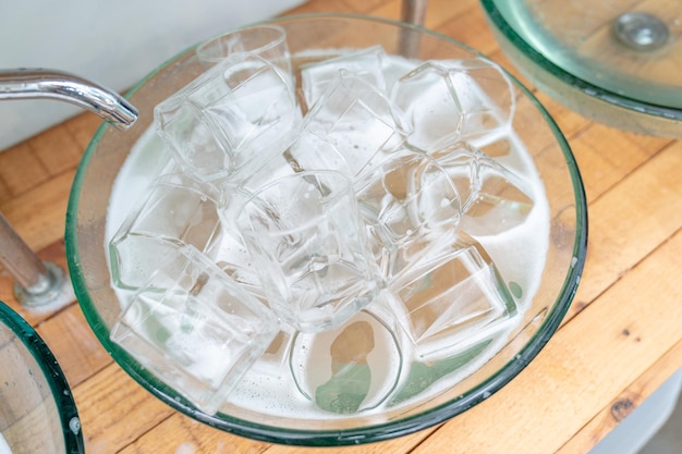 A lot of a glass of water glass in the glass sink ready for washing and clean.