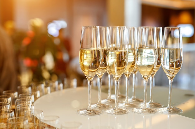 A lot of glasses with champagne or white wine at the event catering.