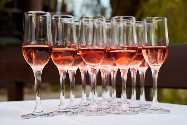 Множество бокалов с розовым вином для гостей на фуршете