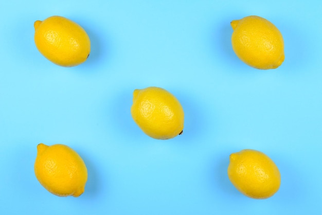 A lot of juicy colorful lemons on blue background Lemons background