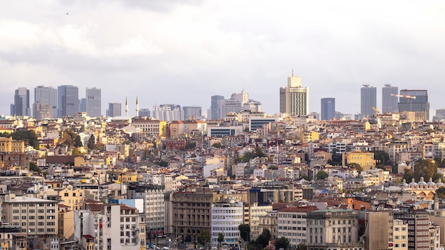 터키 이스탄불의 거리와 흐린 하늘에 낮은 주거 및 높은 현대적인 건물이 많이 있습니다.