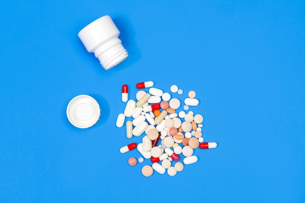 Lot of medical pills and capsules on a blue background