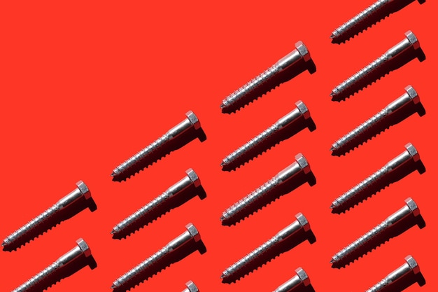 a lot of metal screws on a red background