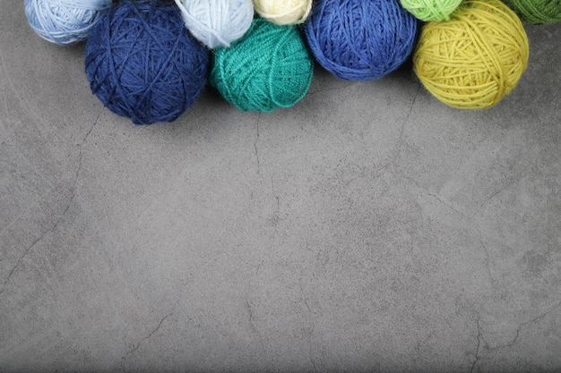 A lot of multicolored yarn balls on the dark background Knitting yarn closeup Knitting is needlework and creativity Copy space