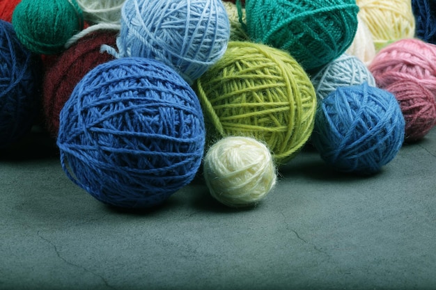 A lot of multicolored yarn balls on the dark background Knitting yarn closeup Knitting is needlework and creativity Copy space