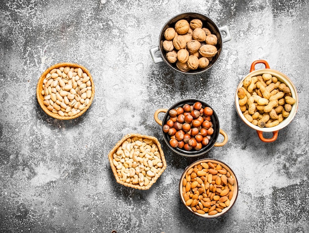 A lot of nuts in different bowls.