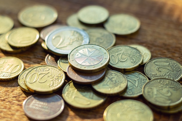 Lot of old rusty brass euro coins on a wooden background