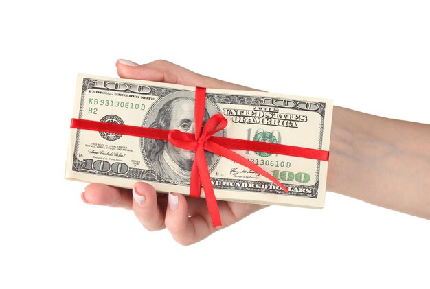 A lot of one hundred dollar bills tied red ribbon in hand isolated on white