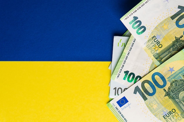 Lot of paper one hundred and fifty euro banknotes on Ukrainian flag Top view Money help concept