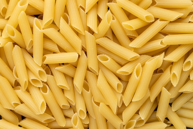 Lot of penne macaroni background texture.