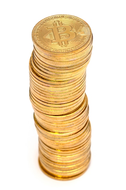 A lot of physical shiny golden Bitcoin are stacked 
